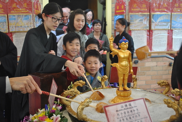 Little boys bathing the little Buddha
