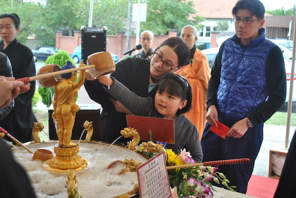 A child bathing the little Buddha